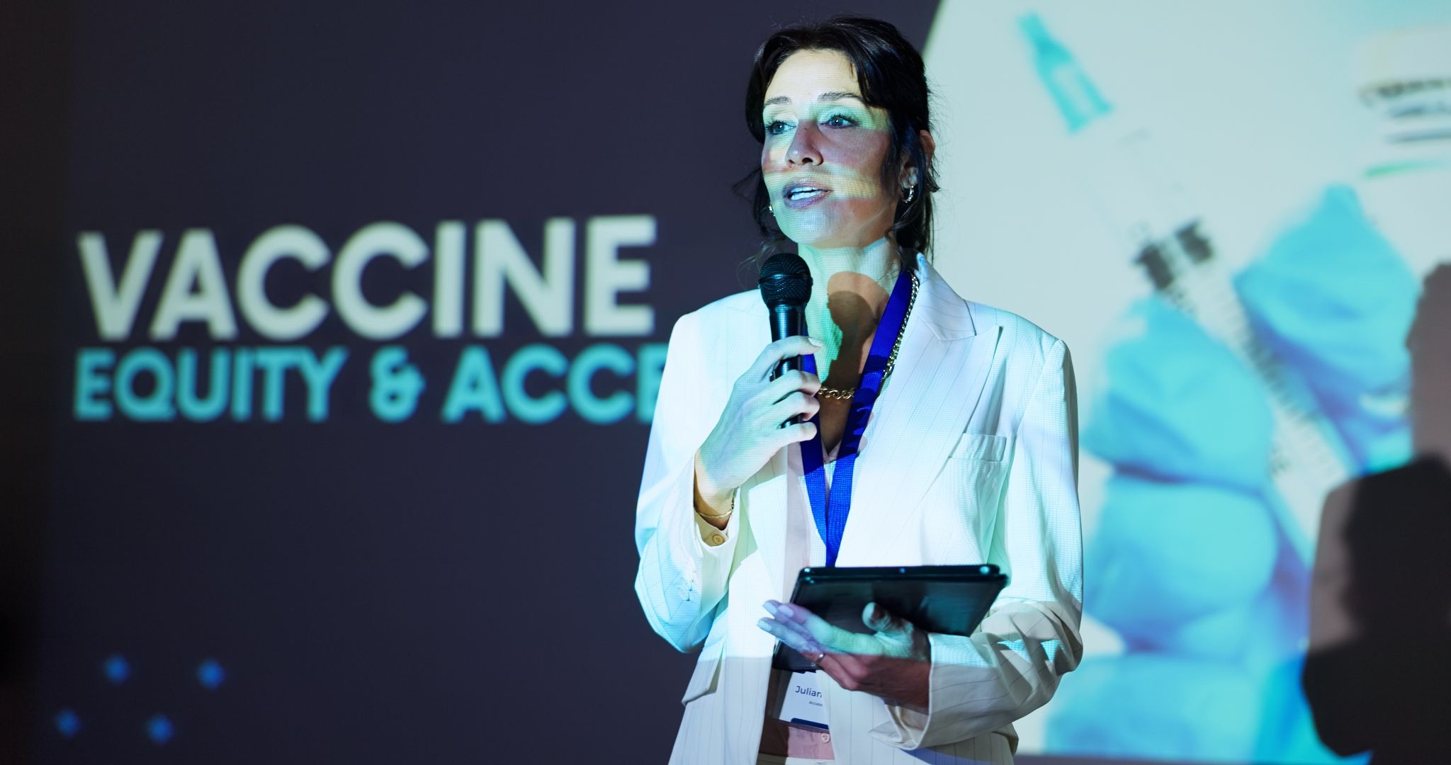 Woman speaking at a pharmaceutical launch event about vaccines, equity, and access